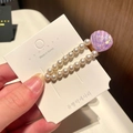 Detail of a pearl hair clip featuring a purple resin shell on a branded display card - 3# Teardrop Shell - Purple
