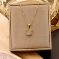 Gros plan du pendentif patte de chat doré avec zircon en cœur sur boîte à bijoux - Chaîne à billes / Or+Blanc