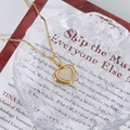 Elegant gold chain necklace with a white mother of pearl heart pendant on ice texture - Gold