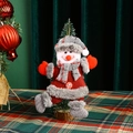 Detail of a plush snowman ornament with red knit fabric and grey checkered hat on a tree - New Dancing Snowman