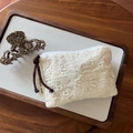 Detail of white floral lace embroidery pouch with brown drawstring and label - Cotton Thread Flower Embroidery