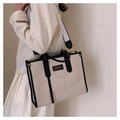 Detail view of canvas tote bag with black leather handles and gold metal accents - Black Large