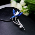 Elegant flower brooch featuring blue enamel petals and a pearl drop on a black display stand - Blue Enamel Flower Pearl