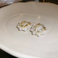 Detailansicht der goldenen Creolen mit weißen Perlenblumen und funkelnden Kristallen - Perle Weiße Blume Stil