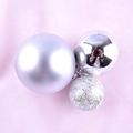 Three silver Christmas cake topper balls in matte, glossy, and glitter finishes on pink mesh - Wish Ball / Silver
