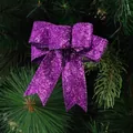 Fiocco decorativo con brillantini viola appeso a un ramo verde di albero di Natale - Viola