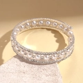 Détail macro d'un bracelet spirale à perles et strass sur support en pierre - Style Spirale à Trois Couches / Argenté