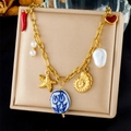 Gouden oceaan ketting met zeester, parel en keramische bedels op beige display - Multi-Hanger Rode Chili Stijl (N3495)