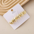 Dettaglio del fermaglio per capelli a cuore dorato con texture martellata su vassoio - Cuore Oro Texturizzato Martellato