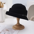 Elegant black French style wool cloche hat with a leather belt buckle on a wooden stand - Black