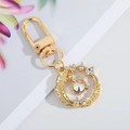 Detailed view of a gold keychain with sparkling rhinestones and leaf texture - Gold Feather Rhinestone 5