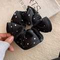 Polka dot black satin scrunchie with ruffled design held by hand for hair styling - Black Polka Dot (Ruffle Edge)