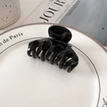 Close-up of a glossy black minimalist hair claw clip on a white ceramic display plate - 7cm / Black