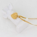 Detail eines strukturierten Herzanhängers aus Gold auf einer weißen Miniatursäule - Goldenes einfaches 3D-Herz (CK1677)
