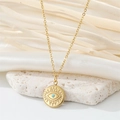 Detail of gold necklace with evil eye pendant and blue stone on white textured stone - Small Round Eye