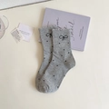 Close-up of grey polka dot socks featuring black bow details and ruffled lace elastic cuffs - One Size / Light Gray
