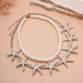 Detail of double-layer necklace with white faux pearls and textured silver starfish pendants - Silver