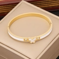 Detail of gold butterfly bangle with white enamel inlay and sparkling side crystals - White