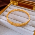 Dettaglio di un bracciale vintage dorato con zirconi e una trama di finitura opaca - Motivo a Onde Dorate (WB1579)