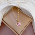 Detailed macro of a gold-plated heart pendant with a pink stone and white zircon border - Pink (G512)