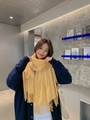 Thick yellow cashmere scarf with fringe on model in a modern indoor setting - Tassel Style / 260g (200x70cm) / Bright yellow