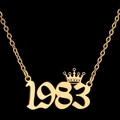 Collar dorado con colgante número 1983 y corona sobre un fondo negro elegante - 1983 / Color Acero