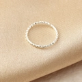 Macro shot of a silver twisted nose ring with textured surface on fabric background - Silver Twisted