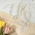 Detail of white lace triangle scarf featuring intricate floral crochet and elegant ribbons - Lace Solid Color / Off White
