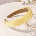 Detail of yellow satin padded sponge headband with non-slip lining on white tabletop - Bright Yellow