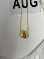 Macro detail of a minimalist gold teardrop pendant on a fine snake chain necklace - 925 Silver / Gold