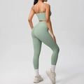 Sage green yoga set detail showing cross back bra and high-waisted lifting leggings - Basil Green