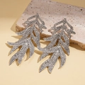 Macro-opname van zilveren bladoorbellen met strass op beige stenen ondergrond - Zilver (Witte Zirconia)