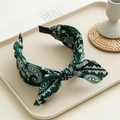 Detailed view of dark green paisley print fabric headband with a bow knot design - Rabbit Ear Paisley / Dark Green