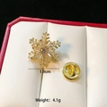 Detailed view of 1.9cm gold snowflake brooch with clear crystals in a red gift box - Rotatable Gold Snowflake C307