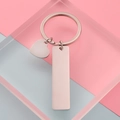 Llavero de oro rosa pulido con dijes de corazón y rectángulo sobre un fondo de estudio - Color Acero