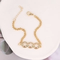 Close-up of gold chain bracelet with multicolor zircon inlays on a white tray - Three Round Zircon Eye Style (15#)