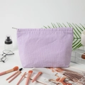 Purple and white seersucker striped cosmetic bag with silver zipper on vanity desk - Purple Striped