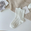 Cozy white cable knit mid-calf socks with ribbed cuffs in a minimalist lifestyle setting - One Size / White