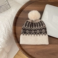 Detailed knit texture of children's geometric wool hat with soft pompom on wood - Hat / Beige