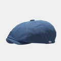 Detailed shot of a dark blue newsboy cap with textured fabric and white JYX embroidery - Blue
