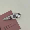 Close-up of a silver hair clip with a large clear crystal on a pink gift card - Silver/White Zirconia-Small Oval