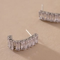 Nahaufnahme silberner C-förmiger Ohrringe mit Zirkonia-Kristallen im Baguetteschliff - Silber (925 Sterling Silber Ohrringstift)