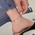 Minimalist stainless steel rose gold anklet with star and bead charms on model - Rose Gold