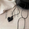 Adjustable black heart pendant necklace with long cord on a minimalist fabric background - Black Heart Pendant / Black