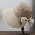 Dettaglio di un cappello da sole in paglia con fiocco in chiffon bianco e trama intrecciata - 56-58cm / Cachi