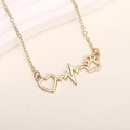 Macro detail of golden heart pendant with cat paw and heartbeat line on a fine chain - Gold