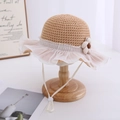 Close-up of girls straw sun hat featuring lace mesh brim, floral accent and chin strap - Coffee