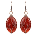 Detailed close-up of handmade tree of life wire-wrapped carnelian earrings in copper - Antique Copper + Red Agate