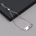 Detail of adjustable skull charm bracelet with engraved silver plaque and cord closure - Box Chain Medical Alert