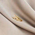 Macro view of gold bunny ear cuff with clear crystals and black eye on silk fabric - Rabbit Head (E5689-18)